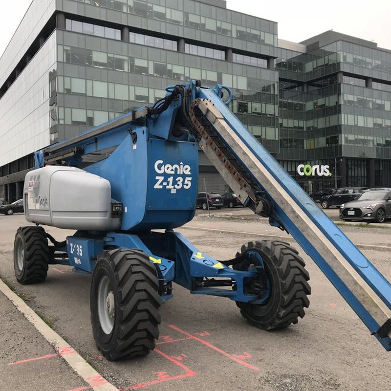 Articulating boom lift parked at a work site